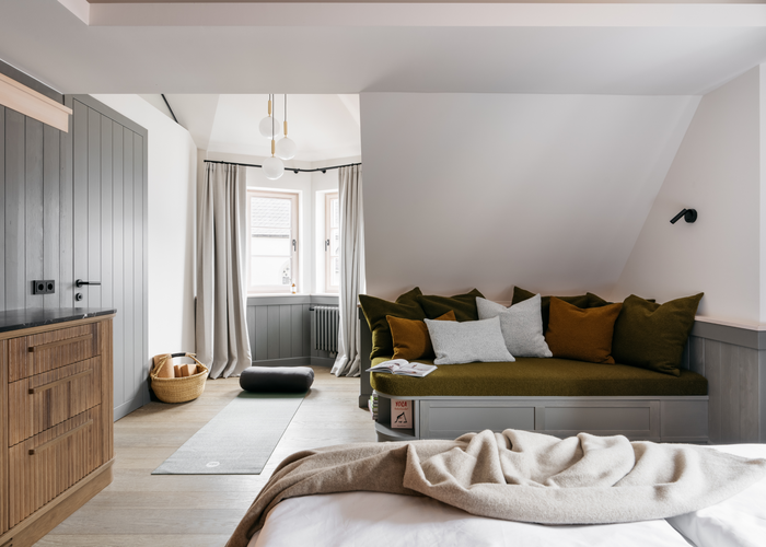 Le porte e i rivestimenti delle pareti verniciati di grigio, insieme ai mobili in legno massello colorato, conferiscono alle camere dei piani superiori un'atmosfera accogliente. | © Refugium Lunz / Gregor Hofbauer