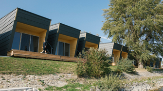 Costruito vicino all'acqua: i capanni neri di GCA Wohnen combinano lavoro e relax in mezzo al verde.  | © GCA Architektur / Nico Havranek