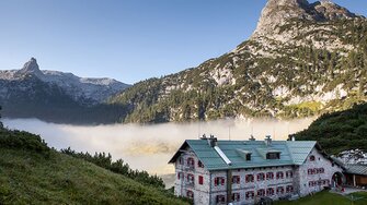 Una vista magnifica: La Kärlingerhaus con le persiane appena dipinte di fronte a un banco di nebbia che si innalza dal Funtensee.