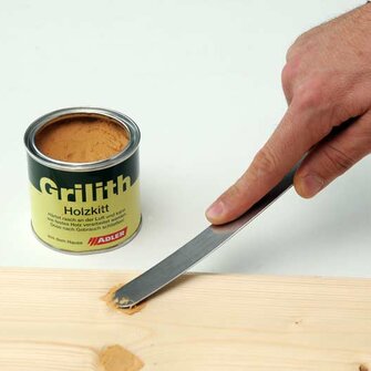 Passo 1: con l'aiuto di una spatola applicare lo stucco per legno all'interno del punto danneggiato.